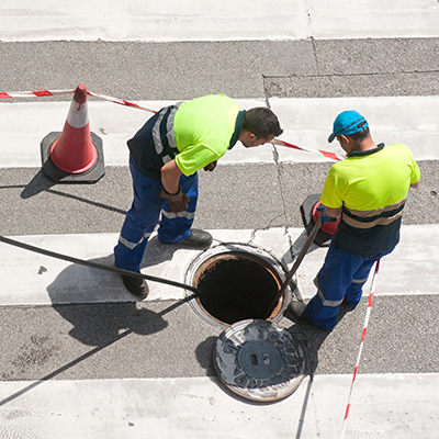 utility workers checking sewer line