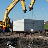 precast vault being lifted with machinery